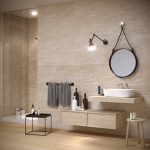 Piastrelle da rivestimento beige in bagno con mobile lavabo, specchio e asciugamani.