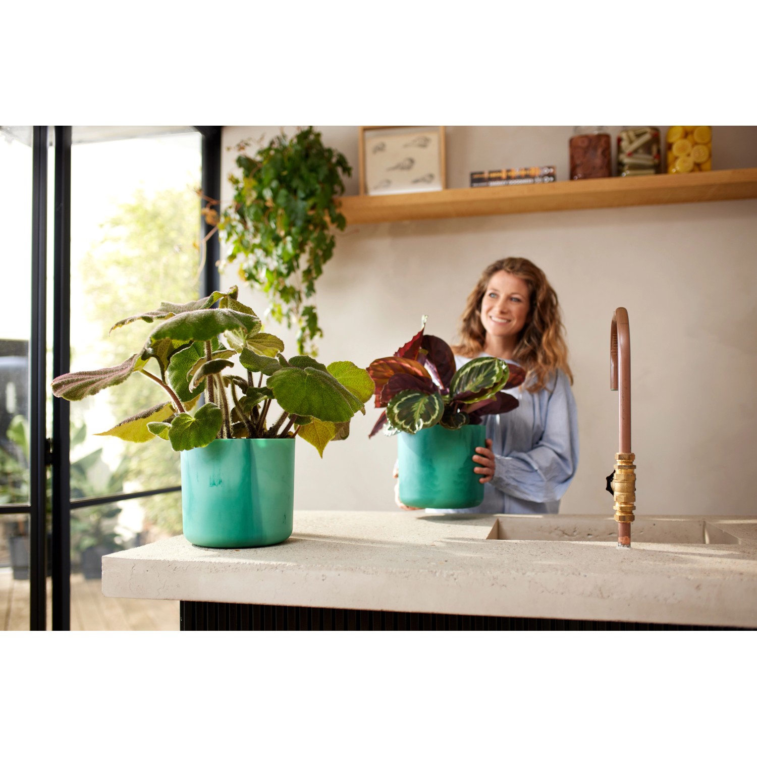 Due vasi per piante Elho Ocean Collection blu atlantico (Ø 16 cm) con piante in cucina moderna.