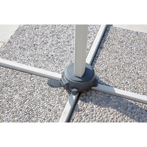 Dettaglio della base per ombrellone t.b.t. su pavimento in pietra. Focus su stabilità e design.