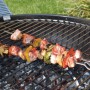 Spiedini con carne e verdure sulla griglia. Accessori per barbecue.
