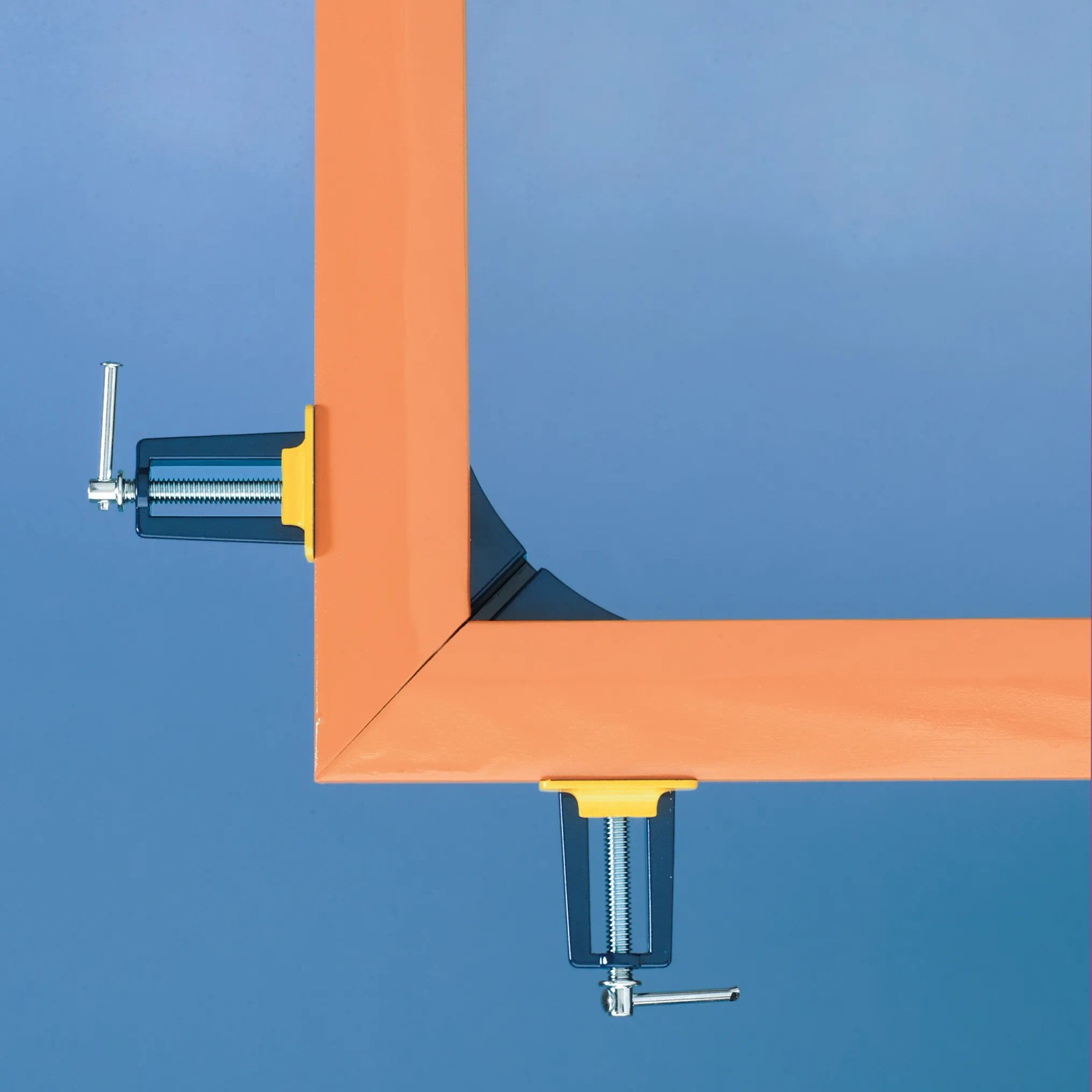 Morsetto per angoli LUX Classic che fissa un telaio arancione a 90 gradi.