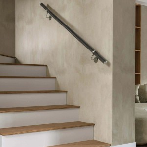 Corrimano nero per scale con staffe su una parete accanto a una scala.
