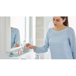 Mensola in vetro Tesa Smooz, cromata, con utensili da bagno e donna in bagno.