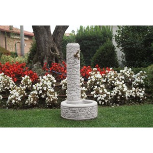 Fontana da giardino t.b.t. grigia con rubinetto davanti all'aiuola.