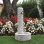 Fontana da giardino t.b.t. grigia con rubinetto davanti all'aiuola.