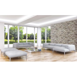 Soggiorno con divano grigio e rivestimento murale in pietra naturale.