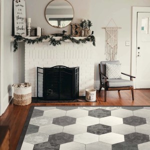 Tappeto moderno con motivo esagonale nei toni del grigio e bianco.