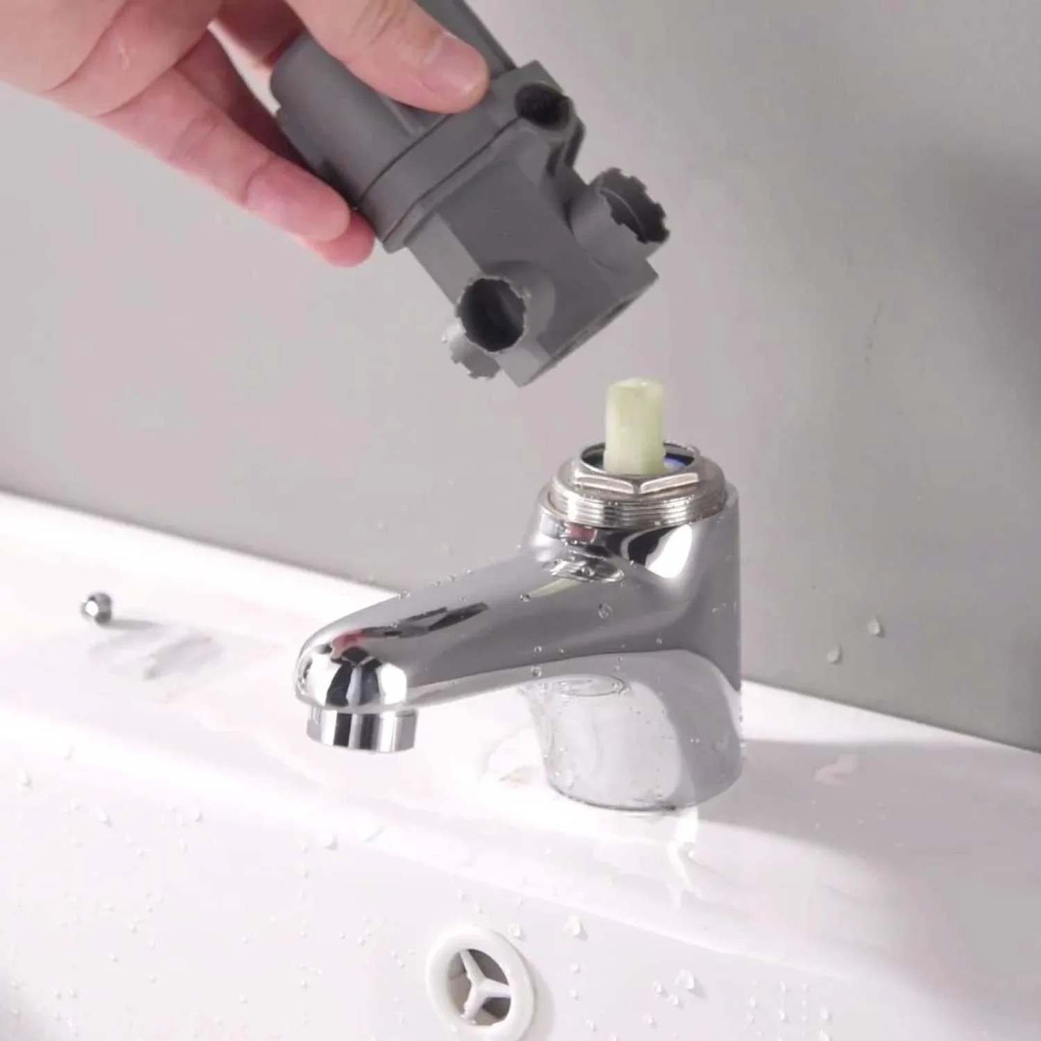 Installazione di un accessorio per rubinetti t.b.t. in bagno.