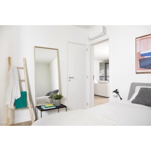 Condizionatore t.b.t. in camera da letto moderna con specchio e scala.