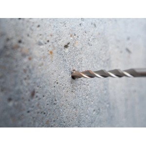 Il trapano a percussione LUX Hammer Classic SDS-Plus fora un foro nel muro di cemento.