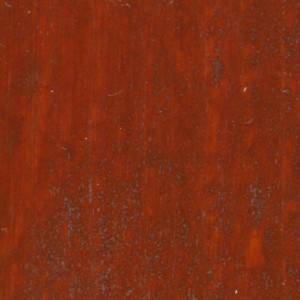 Primo piano di una vernice protettiva per legno color rosso-marrone per esterni.