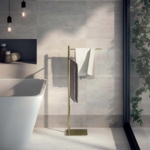 Piantana t.b.t. dorata con asciugamani in bagno moderno.