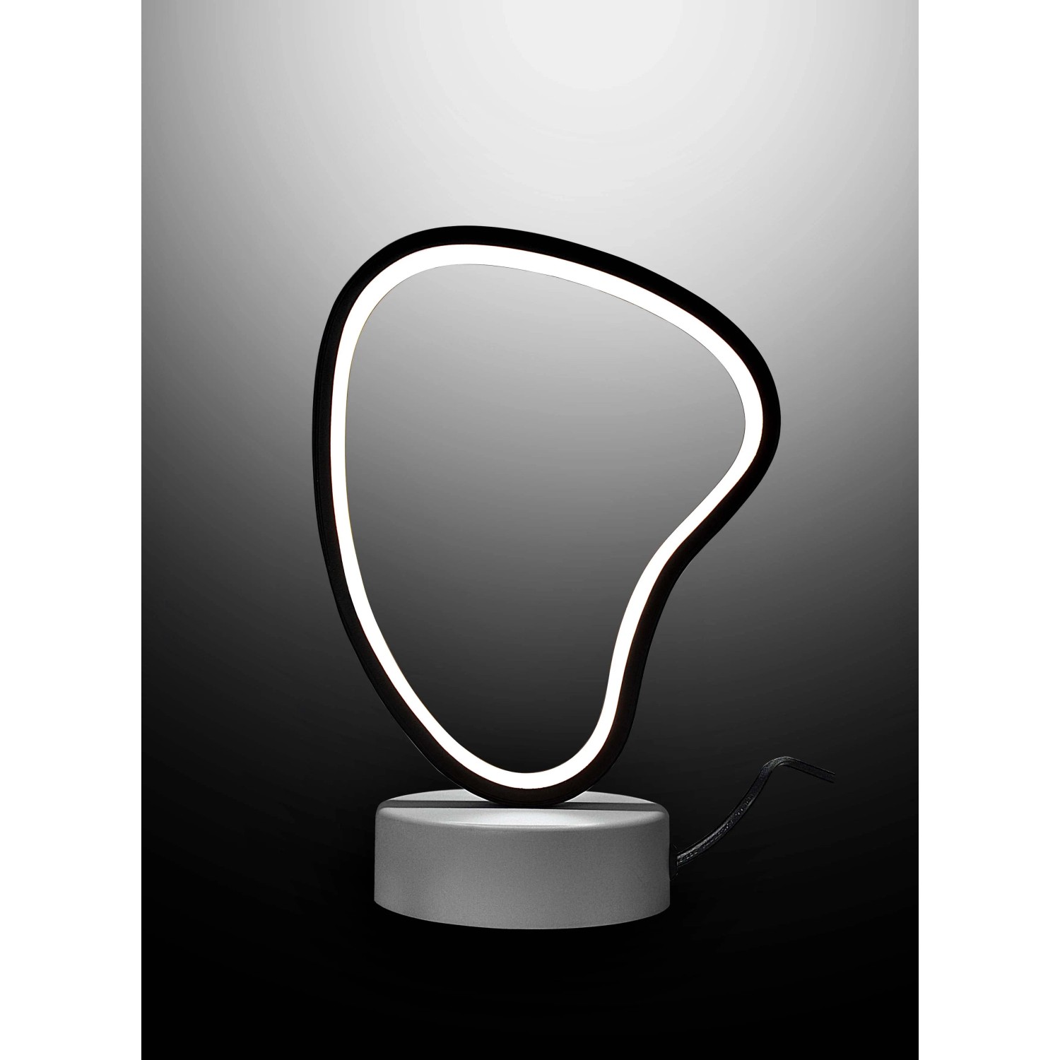 Moderna lampada da scrivania t.b.t. con elemento luminoso a LED di forma asimmetrica.