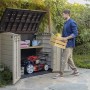 Box universale aperta beige-marrone con tosaerba e uomo con cassa in giardino.