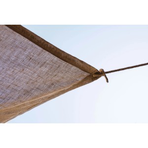 Dettaglio di una vela ombreggiante marrone (t.b.t.) con fissaggio a corda su cielo chiaro.