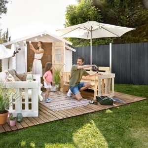 Famiglia in giardino con recinzione privacy in WPC antracite e casetta da giardino.