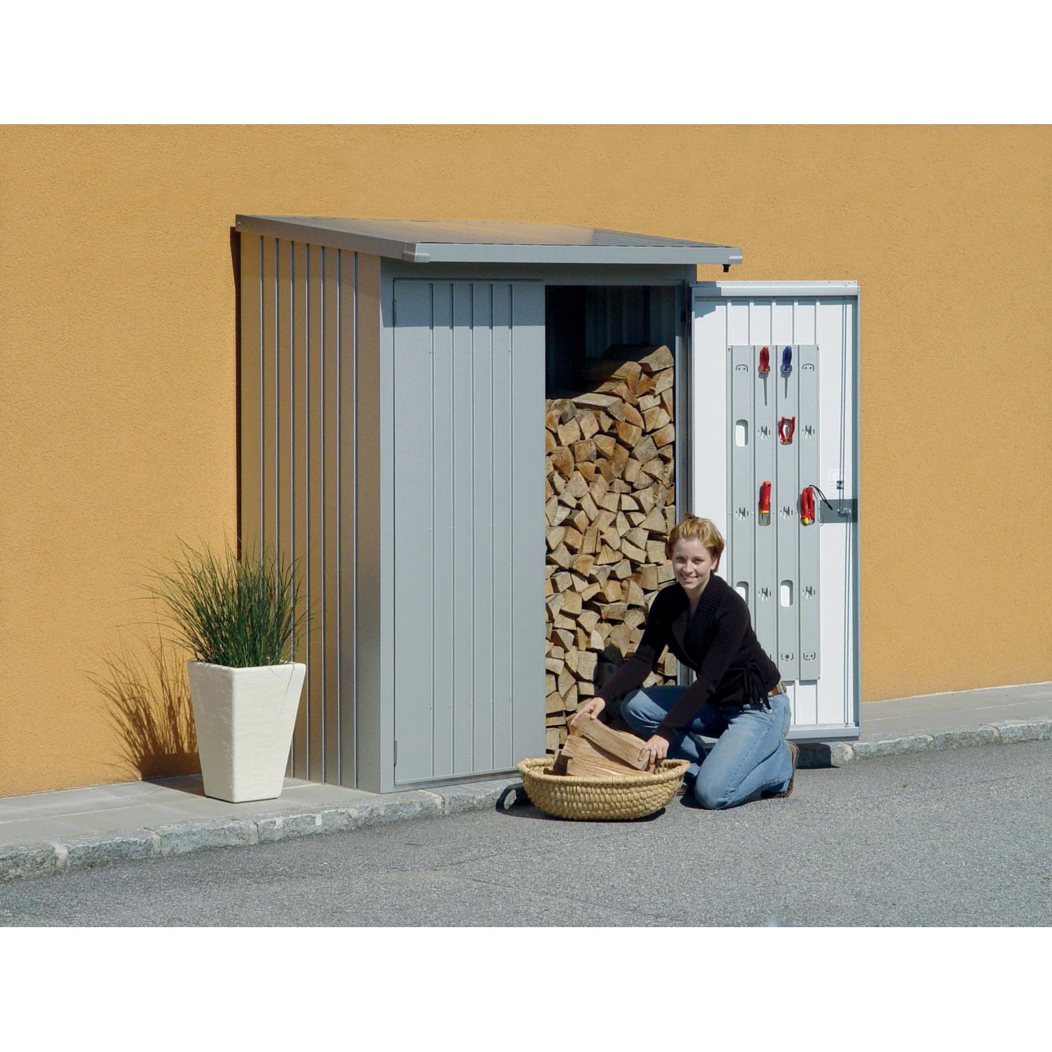 Biohort WoodStock 150, argento metallizzato: Legnaia con legna e donna.