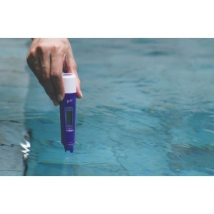 Mano misura la qualità dell'acqua in piscina con un misuratore di pH digitale.
