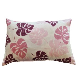 Cuscino decorativo da esterno con foglie di Monstera rosa e bordeaux.