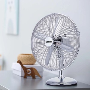 Ventilatore da tavolo cromato su un tavolo. Ideale per rinfrescarsi nelle giornate calde.