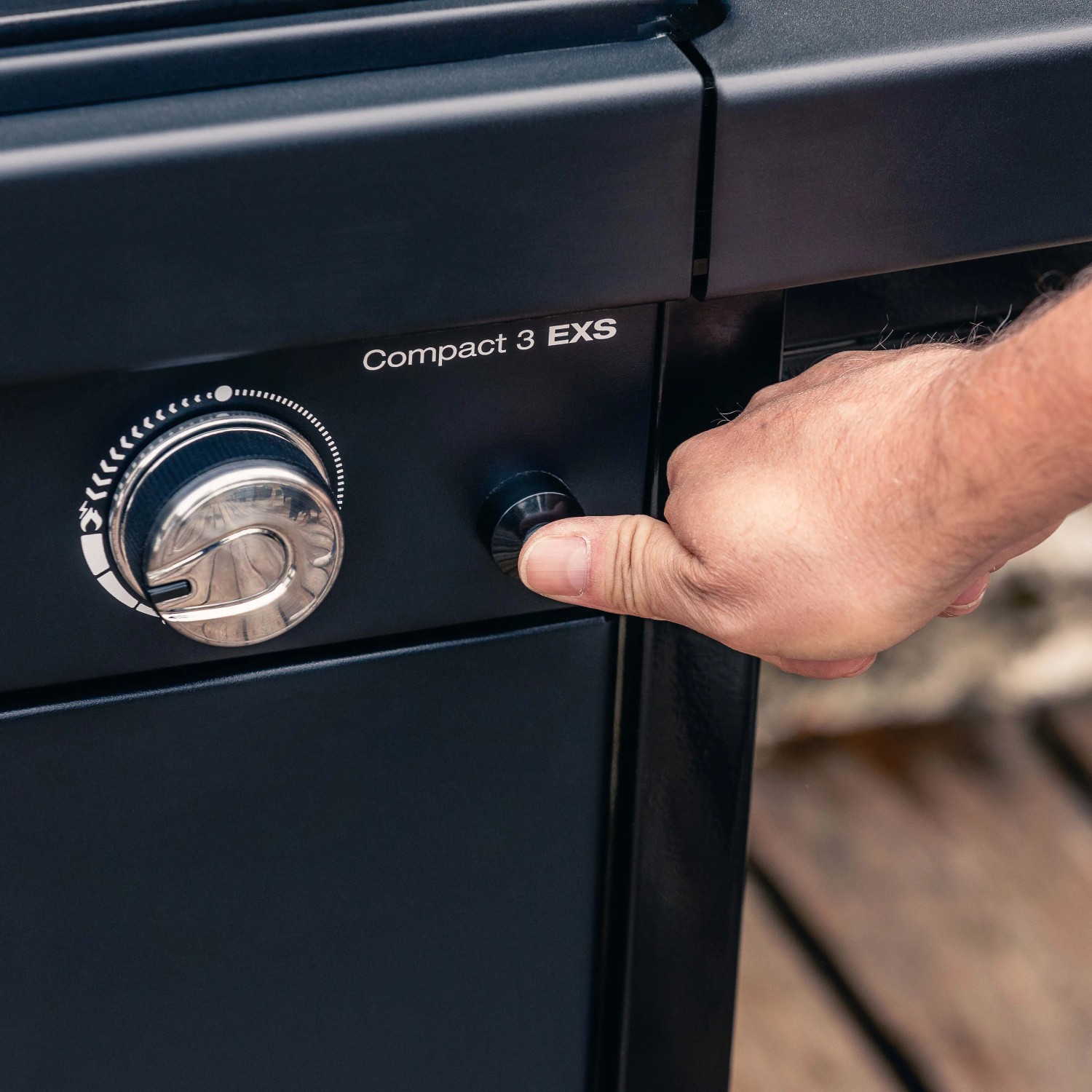 Dettaglio: Mano che aziona la manopola sul barbecue a gas t.b.t.