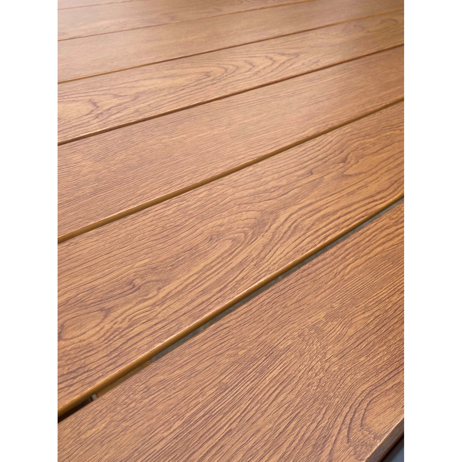 Dettaglio della superficie in legno di un tavolo da giardino. Grana nei toni del marrone caldo.