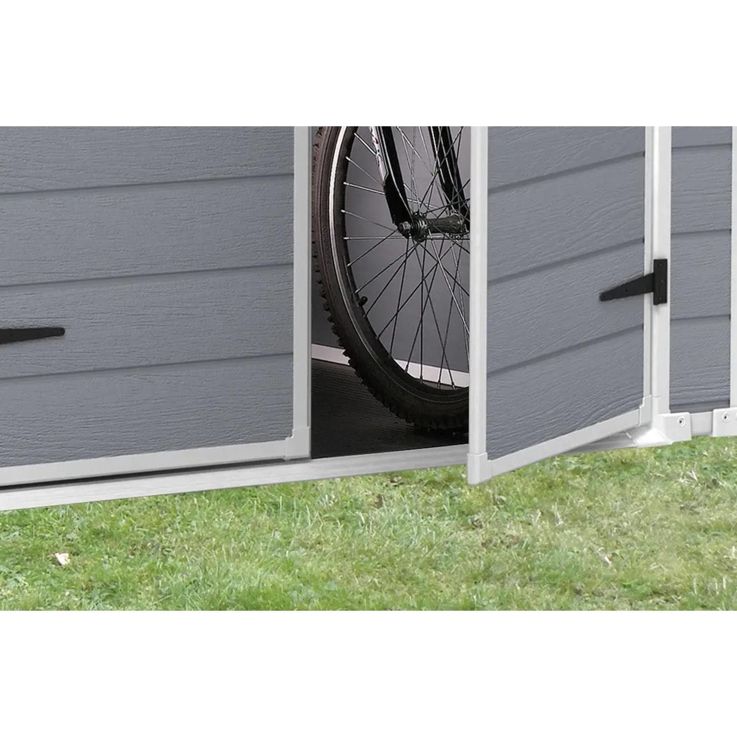 Dettaglio: Casetta da giardino Keter Manor 65DD grigio-bianca con porta aperta e bicicletta all'interno.