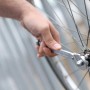 Mano che utilizza la chiave multifunzione LUX Classic su una bicicletta. Chiave inglese per apertura 9-22 mm.