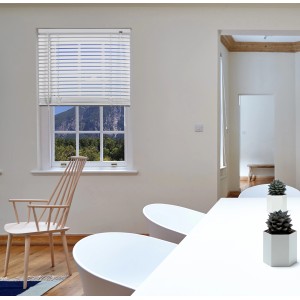 Persiana veneziana bianca t.b.t. su finestra in stanza luminosa.