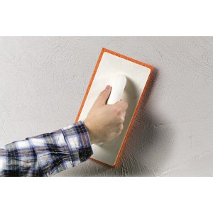 Mano che liscia l'intonaco con spugna LUX Classic 280x140 mm. Strumento per muratura e piastrellatura.