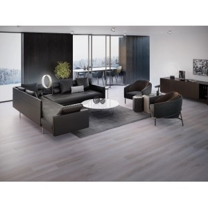 Pavimento vinilico chiaro in soggiorno con divano scuro e tappeto.