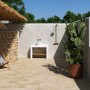 Terrazza con pavimentazione per esterno t.b.t., sedia a sdraio e cactus in vaso.