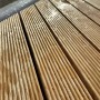 Primo piano di assi di legno scanalate, forse per una zona doccia.