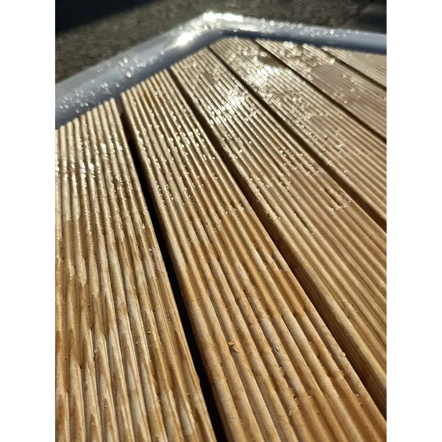 Primo piano di assi di legno scanalate, forse per una zona doccia.