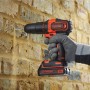 Avvitatore a percussione Black+Decker BDCHD18K che fora un muro di mattoni.