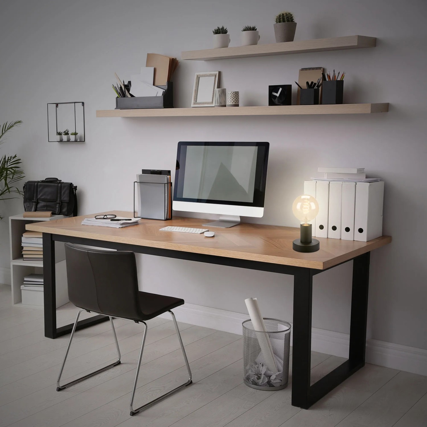 Lampada da tavolo nera Brilo Teepu su scrivania con PC e forniture per ufficio.