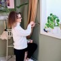 Donna che fissa un bastone per tende con un cacciavite. Sparachiodi per il fai da te.