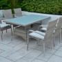 Set di mobili da giardino grigio in rattan con tavolo e sedie.