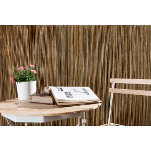 Schermo per la privacy naturale, stuoia di bambù come Arelle, con tavolo e sedia in giardino.