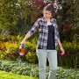 Donna che sparge fertilizzante con lo spargitore Gardena Small S Turchese in giardino.