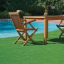 Superficie in erba sintetica verde con tavolo e sedie a bordo piscina. Ideale per giardino e terrazza.