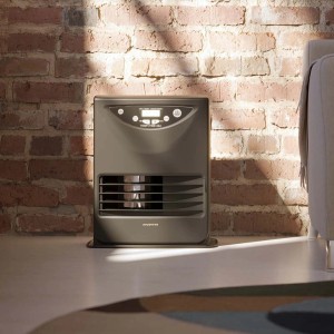 Stufa grigia t.b.t. davanti a un muro di mattoni. Riscaldatore con display digitale.