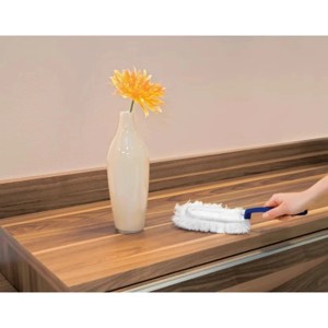 Spolverino con manico blu su superficie in legno. Ideale per la pulizia.