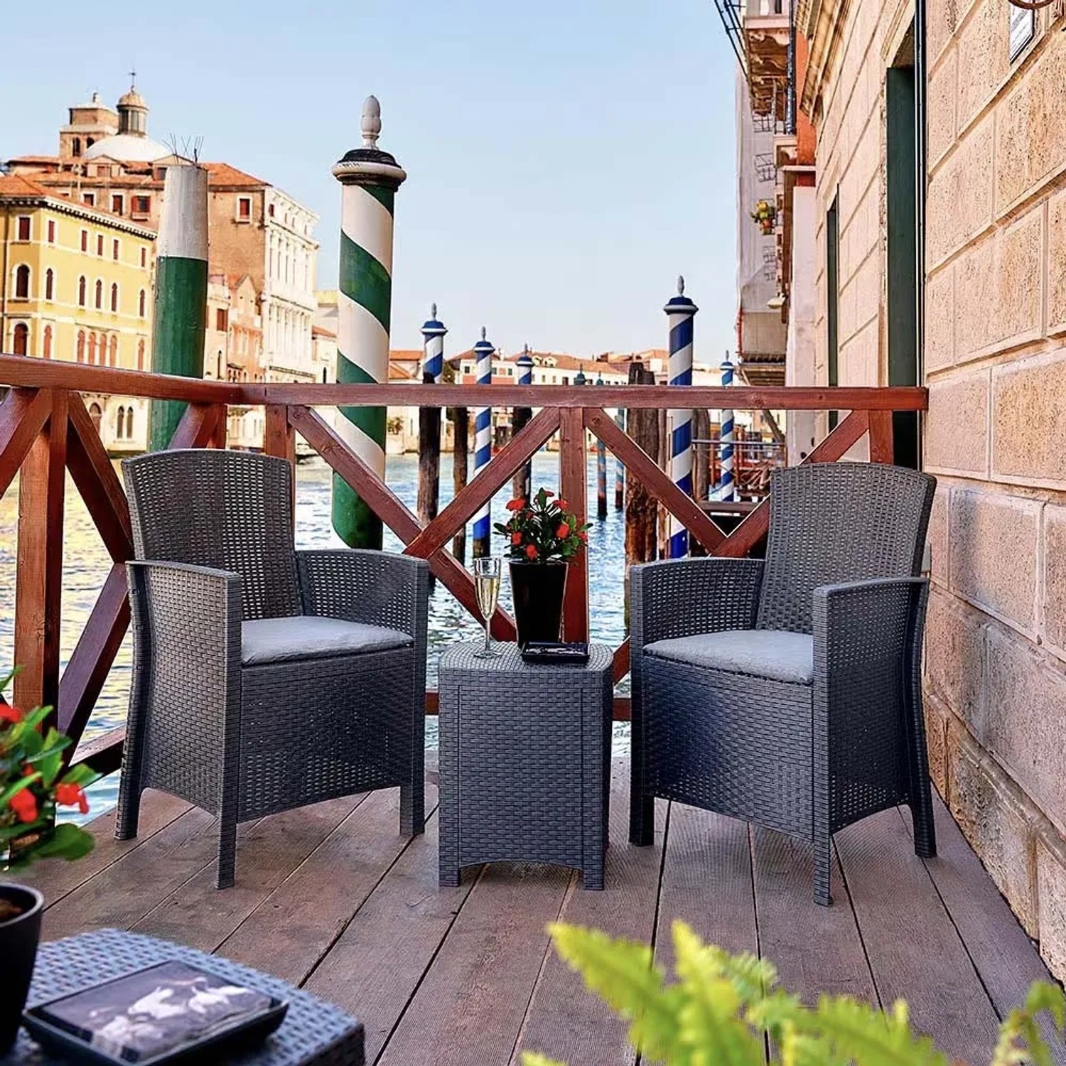 Set di mobili da giardino t.b.t. grigio con due poltrone e tavolo su una terrazza con vista su Venezia.