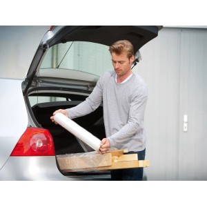 Uomo che imballa legno con pellicola estensibile LUX (0,5 m x 120 m) nel bagagliaio.