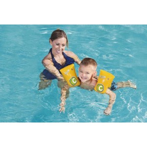 Bambino con braccioli gialli t.b.t. in piscina. Aiuto per il nuoto per bambini.