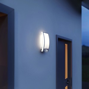 Moderna lampada da parete per esterni Steinel L22 S in acciaio inox con rilevatore di movimento su parete di casa.