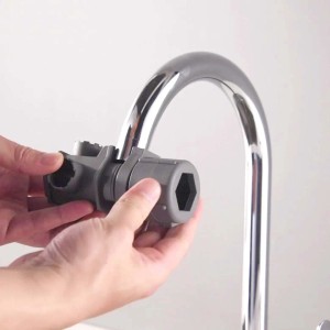 Attrezzo t.b.t. grigio fissato a un rubinetto. Accessori per idraulica.