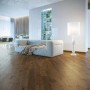 Parquet scuro posato in soggiorno con divano e lampada.