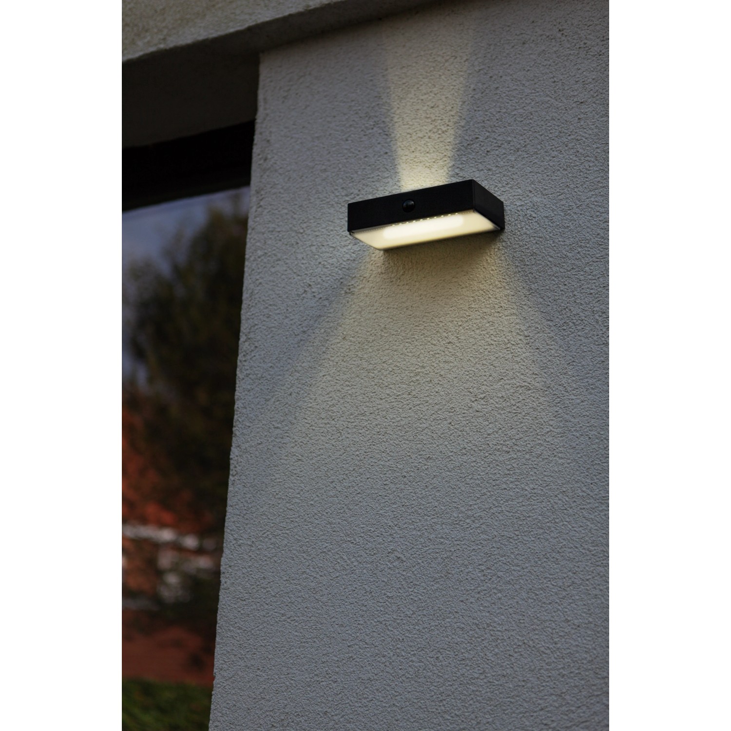 Lampada da parete solare a LED nera Lutec Fadi con sensore di movimento e luce bianca calda.